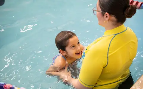 Smiling child floating on her back in the Super Aqua pool